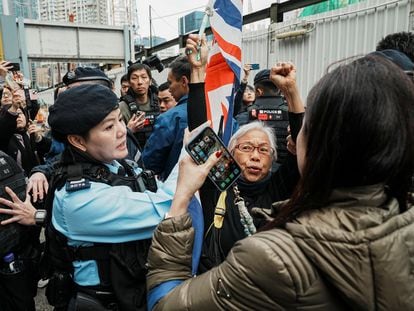 Un miembro del personal de seguridad detiene a un simpatizante que ondea la bandera de la Unión Jack a las puertas del Tribunal de Magistrados de West Kowloon durante el juicio al magnate de los medios de comunicación Jimmy Lai, en Hong Kong, este lunes.
