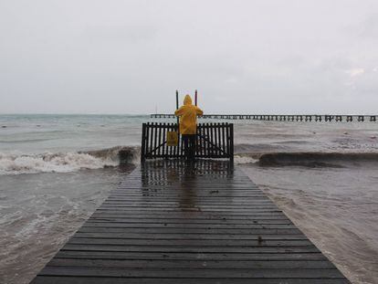 Un hombre toma fotos al mar durante el paso del Huracán Delta en Cancún.