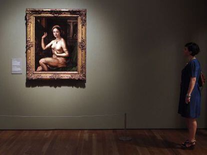 Una mujer contempla una 'Mujer ante el espejo', de Giulio Romano, discípulo de Rafael, en la exposición del Museo del Prado