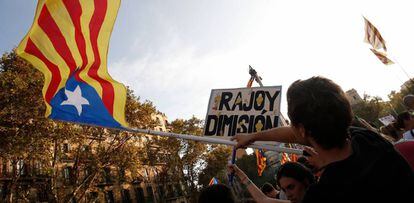 Un hombre sostiene una estelada junto a una pancarta de "Rajoy dimisión" durante la huelga general en Barcelona.