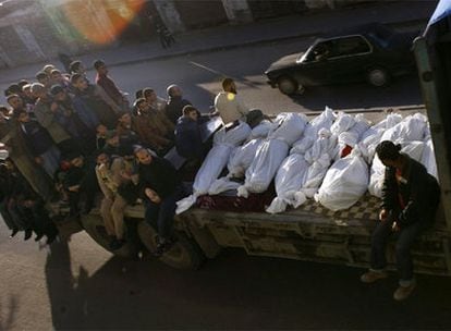 Un grupo de palestinos transporta los cadáveres de 13 miembros de la misma familia que murieron tras un bombardeo de la aviación israelí.