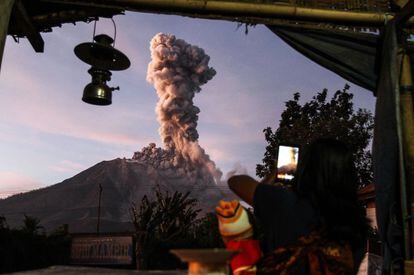 Un aldeano indonesio toma una foto del volcán Mount Sinabung mientras arroja un denso humo. La imagen está tomada desde la aldea de Tiga Pancur en Karo, Sumatra del Norte.