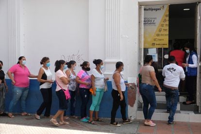 Habitantes de Santa Marta, Colombia, hacen fila afuera de un banco.