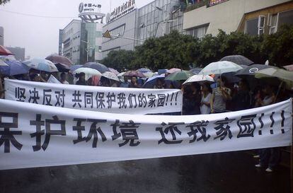 Manifestaci&oacute;n contra una f&aacute;brica de cobre en Shifang, el lunes. Las pancartas dicen: &quot;&iexcl;Proteged el medio ambiente, devolvednos nuestra tierra!&quot; y &quot;Protesta y &uacute;nete para defender nuestra tierra&quot;.