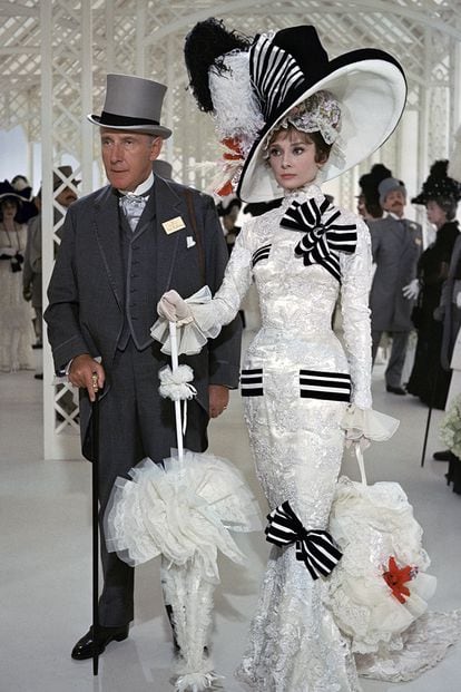 Audrey Hepburn, My Fair Lady - 

De los ocho premios Óscar recibidos en 1964 por el inolvidable musical de George Cukor, el otorgado al diseño de vestuario es uno de los más incontestables. Cecil Beaton, cuya ocupación principal por aquel entonces era la de fotógrafo en revistas de moda, diseñó más de mil vestidos para el filme. Este vestido de encaje con lazos que lucía Eliza Doolitle en su presentación en las carreras de caballos de Ascot es la joya de la corona, como lo demuestran los más de tres millones de euros que un pujador desembolsó por él.