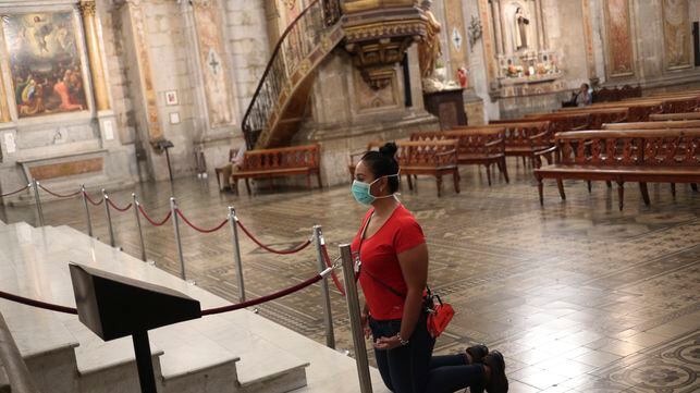 A woman wearing a face mask as a precaution against the spread of the new coronavirus prays at the Cathedral in Santiago, Chile, Wednesday, March 18, 2020. The vast majority of people recover from COVID-19. (AP Photo/Esteban Felix)