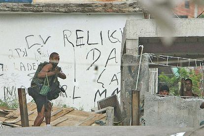 Un grupo de hombres armados se enfrenta a agentes de la Policía Federal en el Complexo do Alemão, ayer en Río de Janeiro.