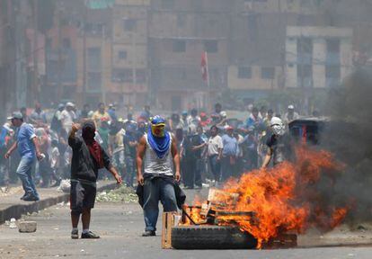 Manifestantes contra el cierre de un mercado en Lima incendian barricadas.