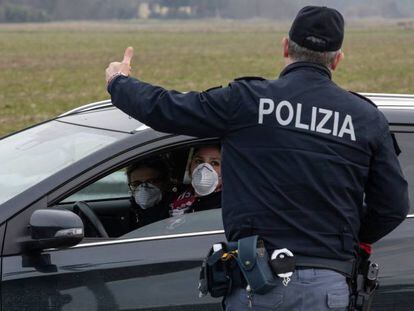 Un policía italiano habla con un conductor en los alrededores de Casalpusterlengo, una de las localidades conde las autoridades han decretado la cuarentena.  