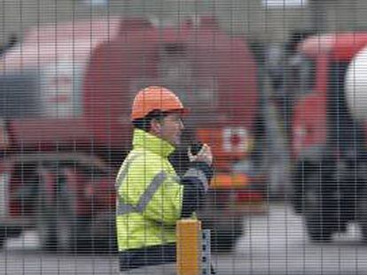 Un operario habla por un "walkie-talkie" mientras unos camiones cisterna esperan para cargar gasolina en el depósito de combustible de Kingsbury, Reino Unido. EFE/Archivo