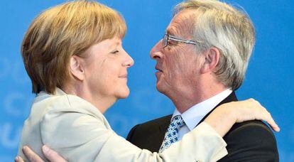 Merkel y Juncker se abrazan durante la campa&ntilde;a electoral de mayo. 