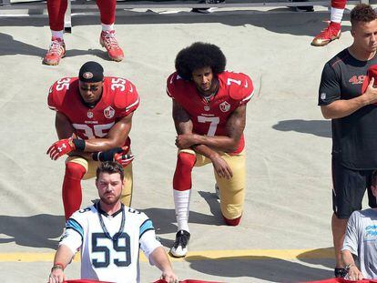 Colin Kaepernick y uno de sus compa&ntilde;eros se arrodillan ante el himno en se&ntilde;al de protesta.