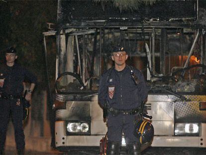 Dos policías ante el autobús incendiado anoche en Marsella