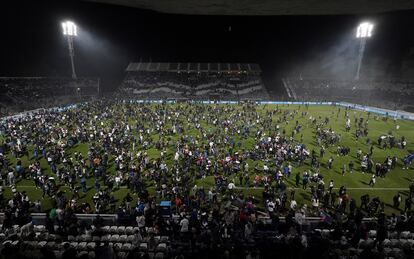 Con las puertas del estadio cerradas, los aficionados invadieron el campo de juego mientras fuera todavía se escuchaban disparos.