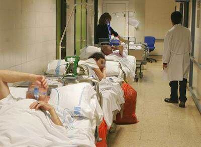 Varios pacientes esperan ayer en un pasillo de la zona de urgencias del hospital La Paz.