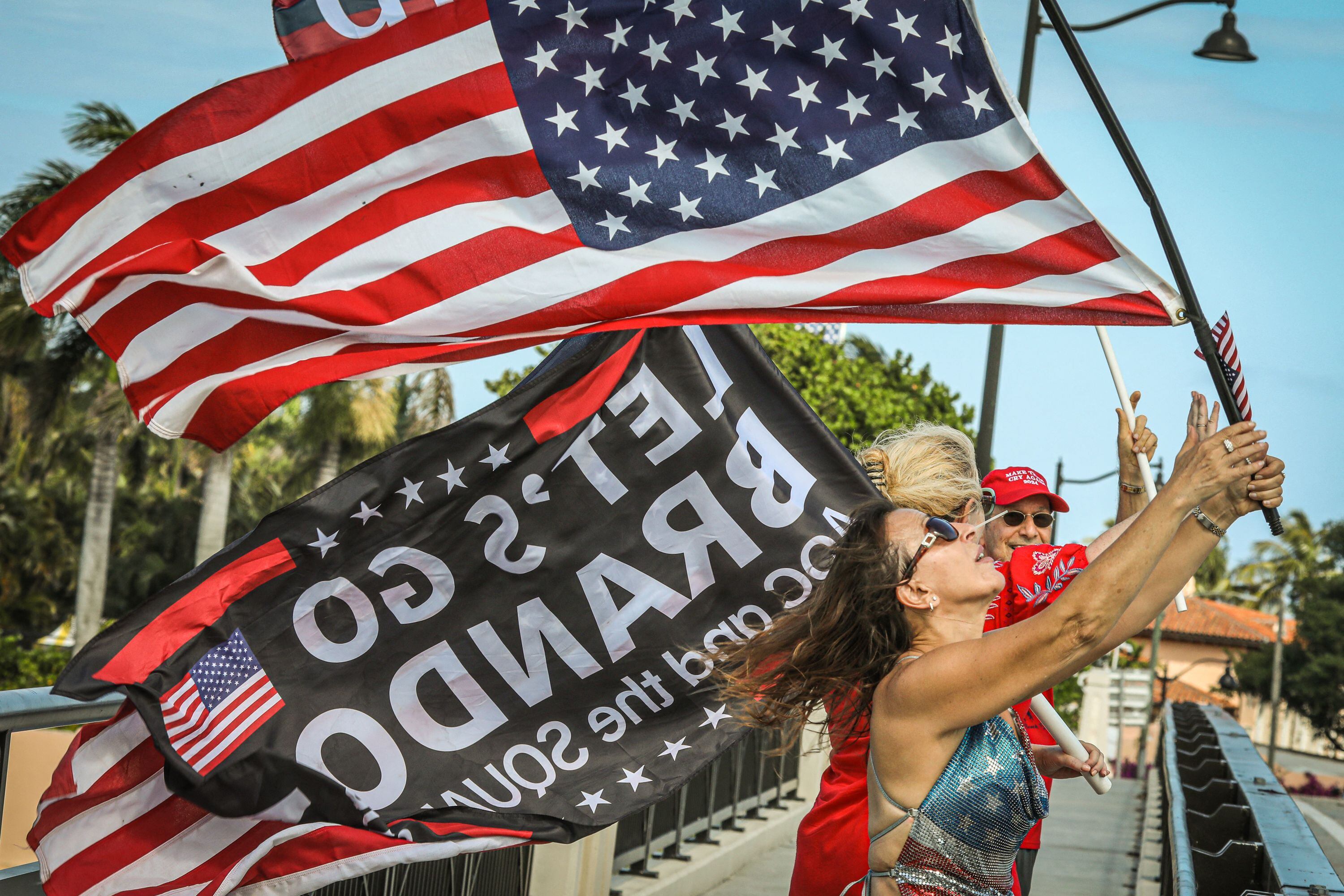 Simpatizantes de Trump apostados en el puente que lleva a su residencia de Mar-a-Lago, en Palm Beach, el 1 de abril. 