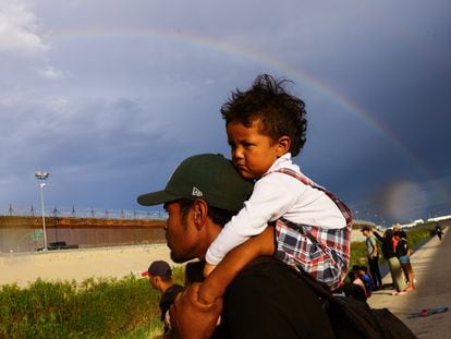 Un hombre carga a su hijo mientras busca asilo en Estados Unidos, a orillas del río Bravo, el 12 de septiembre de 2023.