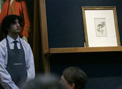 Uno de los empleados de la sede londinense de Christie&#39;s custodia el dibujo de Goya durante la subasta.