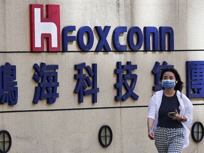 Una mujer pasa junto al logotipo de Foxconn en el exterior del edificio de la empresa en Taipei, Taiwán.