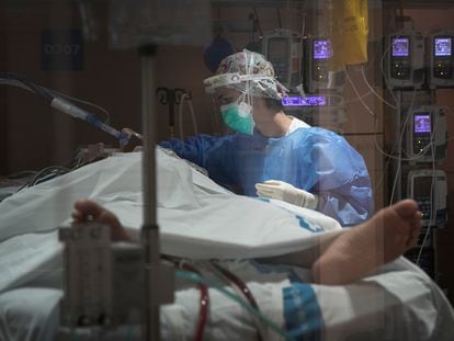 Una sanitaria atiende a un paciente ingresado en la UCI Covid del Hospital Vall D'Hebron de Barcelona.