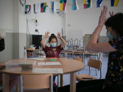 Una maestra con dos alumnas en una escuela de Barcelona, en junio.