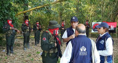 Funcionarios de la  Defensoría del Pueblo hablan con guerrilleros del ELN, durante la liberación de varios soldados y un policía en zona rural de Arauca, el 17 de agosto de 2022.