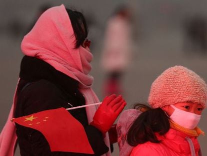 Una mujer y su hija se protegen de la contaminación de Pekín.