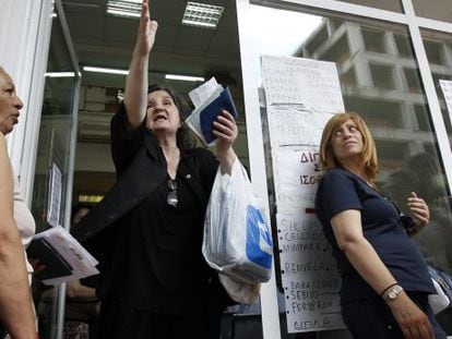 Unas mujeres aguardan en la entrada del Fondo de Salud Estatal para recibir medicamentos en Atenas.