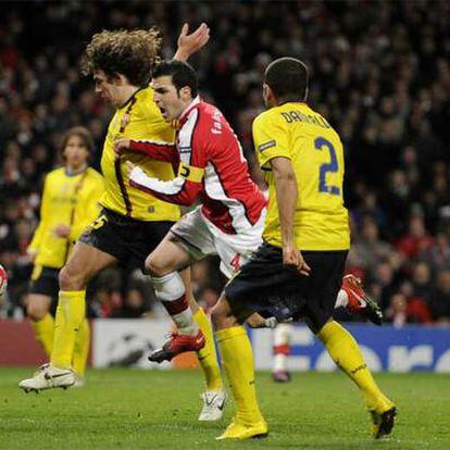 Cesc, entre Puyol y Alves, en la jugada que acabó en penalti para el Arsenal ante el Barça en marzo pasado.