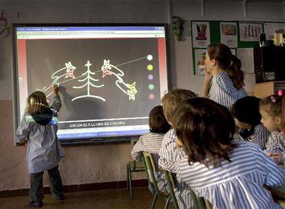 Alumnos de un colegio de Vilassar de Dalt utilizan una pizarra digital.