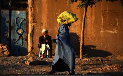 Una afganesa carrega un paquet sobre el cap, aquest divendres en una carretera de la província d'Herāt.