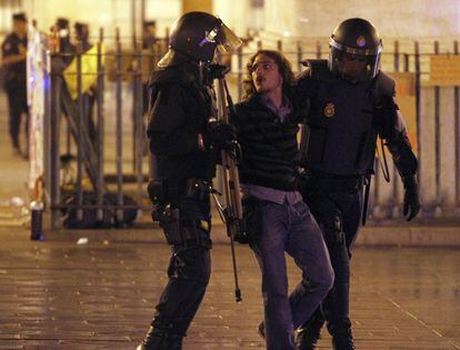 Los agentes se llevan a una de las personas que se resistía a abandonar la Puerta del Sol pasadas las 4 de la madrugada del martes 15.