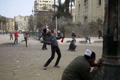 Manifestantes tiran piedras a la policía durante los enfrentamientos en el segundo aniversario de la revolución egipcia en la plaza de Tahrir del Cairo.