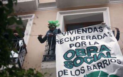 Tres activistas fijan un cartel en el edificio okupado en enero.