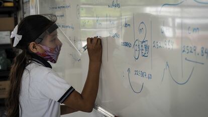 Una alumna escribe en el pizarrón durante el regreso presencial a las escuelas, tras más de un año de cierre por la pandemia de covid 19, en noviembre de 2022.