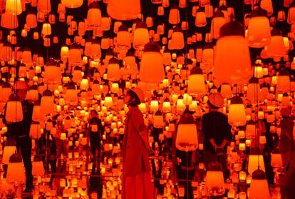 Varias personas en una instalación digital denominada "Forest of Resonating Lamps" en el Museo de Arte Mori, en Tokio (Japón).