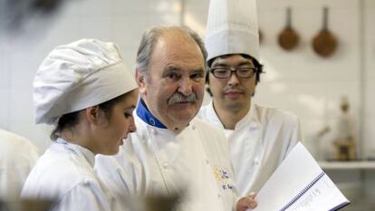 Luis Irizar, en el centro, junto a dos alumnos en su escuela de cocina, en San Sebastián.