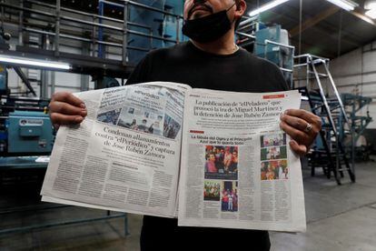 Un empleado de 'elPeriódico' muestra una copia de la edición 
 del 1 de agosto, en la que se condenan los actos en contra del diario y su fundador.