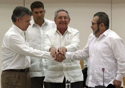 Juan Manuel Santos y Timochenko, líder de las FARC, se dan la mano en La Habana ante el líder cubano Raúl Castro, el pasado septiembre