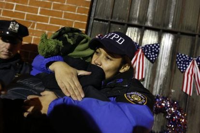 Una policía abraza a otra persona durante la vigilia de Brooklyn.
