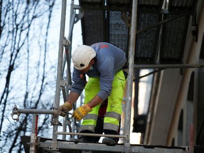 Un obrero de la construcción trabaja sobre un andamio en una imagen de archivo.