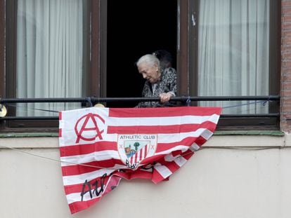 Una mujer junto a una bandera del Athletic antes de las últimas finales de Copa.