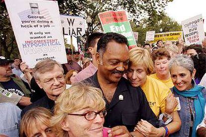 Joan Baez (primera por la derecha) toma el brazo de Cindy Sheehan, aferrada al reverendo Jesse Jackson.