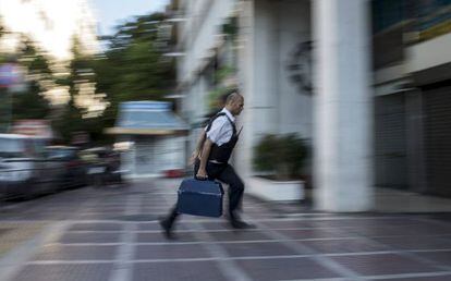Un empleat de seguretat porta diners a una sucursal bancària a Atenes.