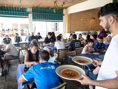 Un camarero atiende a los clientes en una terraza de un restaurante de Málaga.
