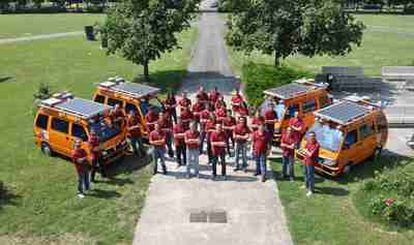 Los cuatro automóviles eléctricos dotados de paneles solares y piloto automático junto a los participantes en el proyecto, en Parma al inicio de la expedición.