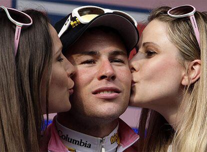 Cavendish, en el podio, recibe dos besos de las azafatas por haber ganado la etapa.