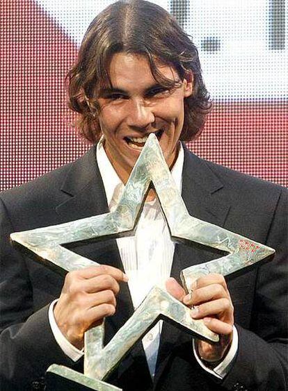 El tenista Rafael Nadal muerde el I Premio Internacional del Deporte de la Comunidad de Madrid.