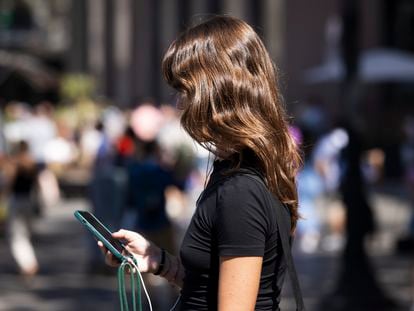 Una dona amb el seu mòbil al centre de Barcelona.