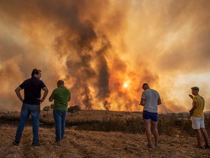 Vecinos contemplan el incendio de Almonaster (Huelva).